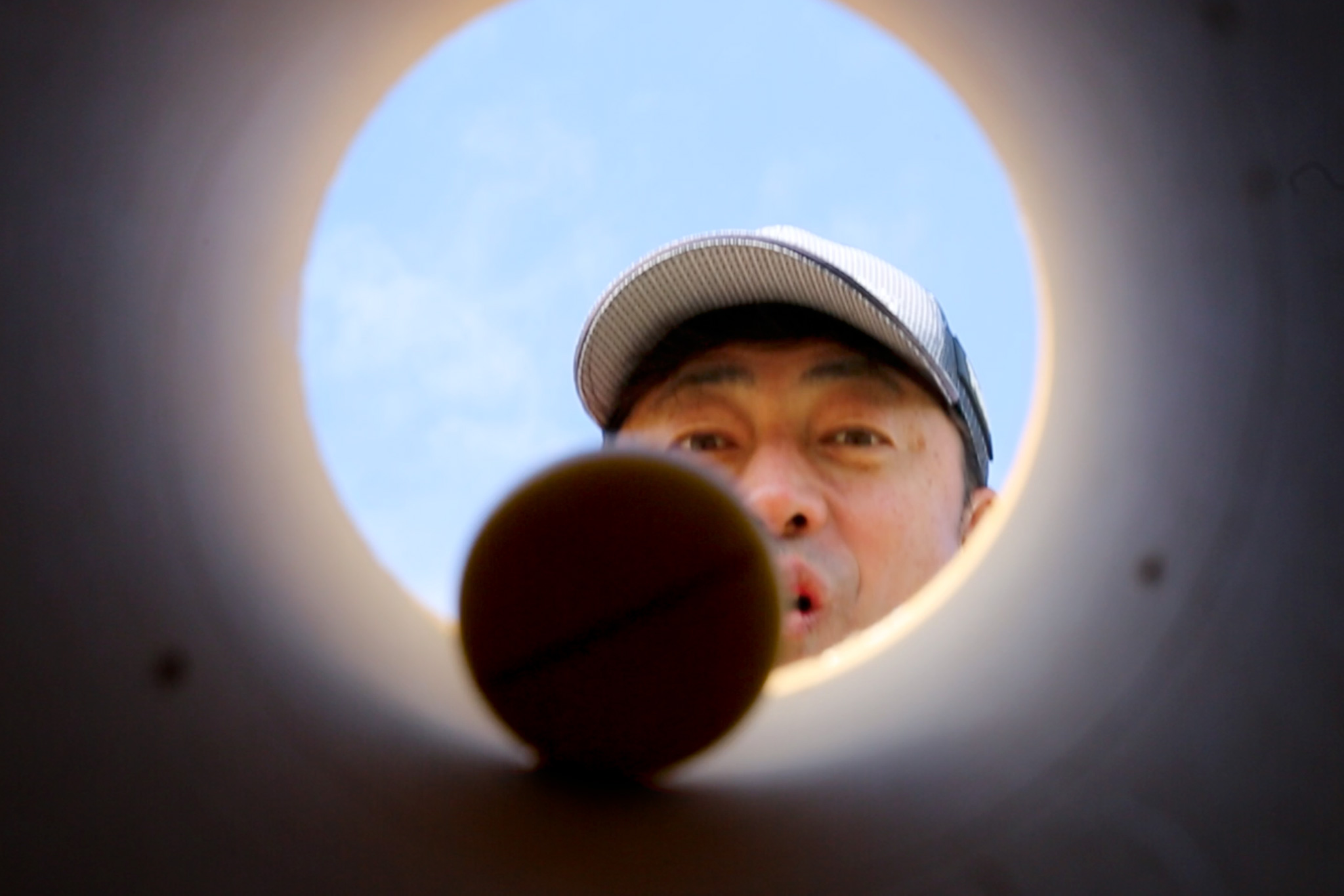 カップを覗く関西ゴルフサークル セブンエイトの湯浅浩由さん